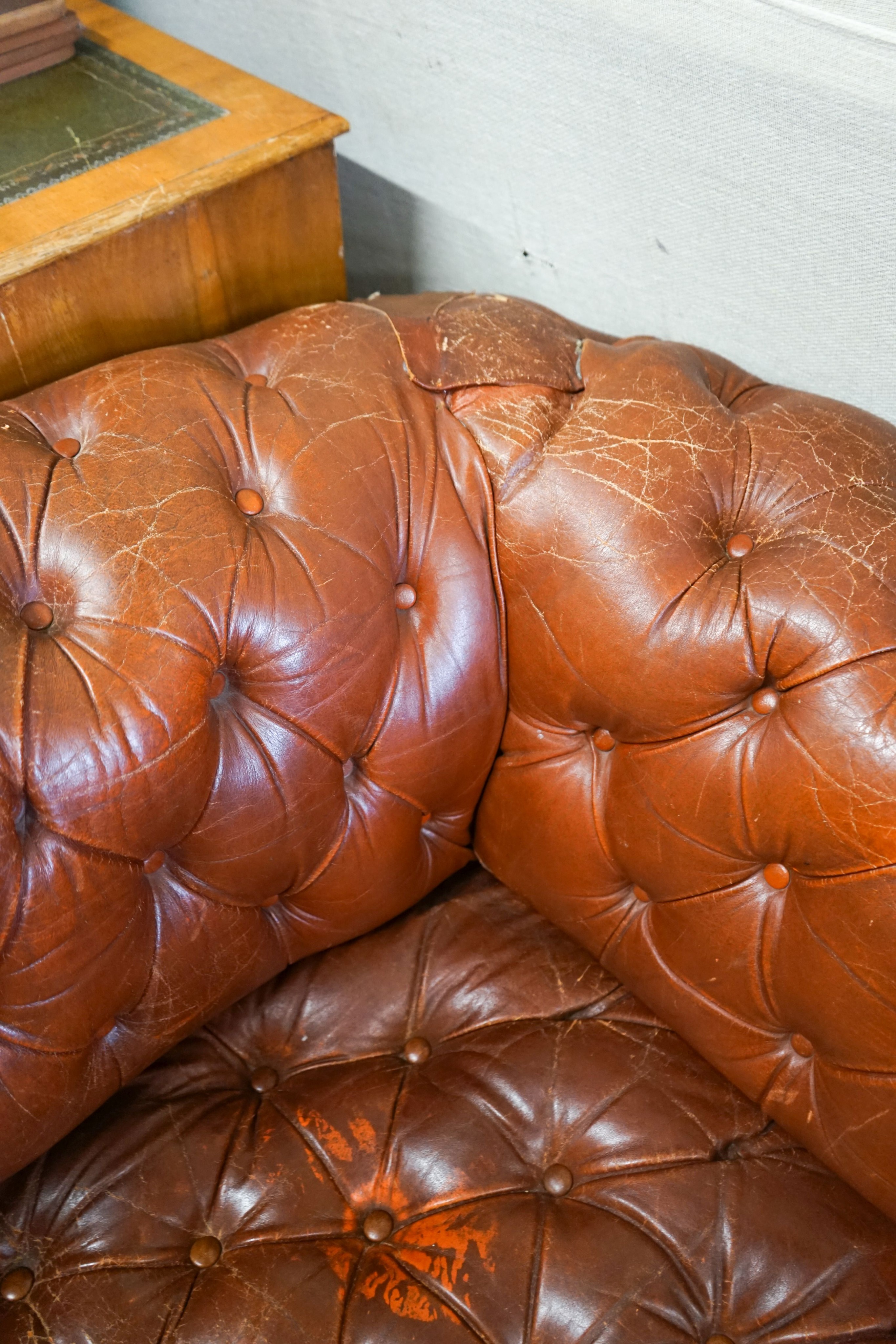 A late Victorian drop arm leather button back Chesterfield settee, length 170cm, depth 88cm, height 70cm